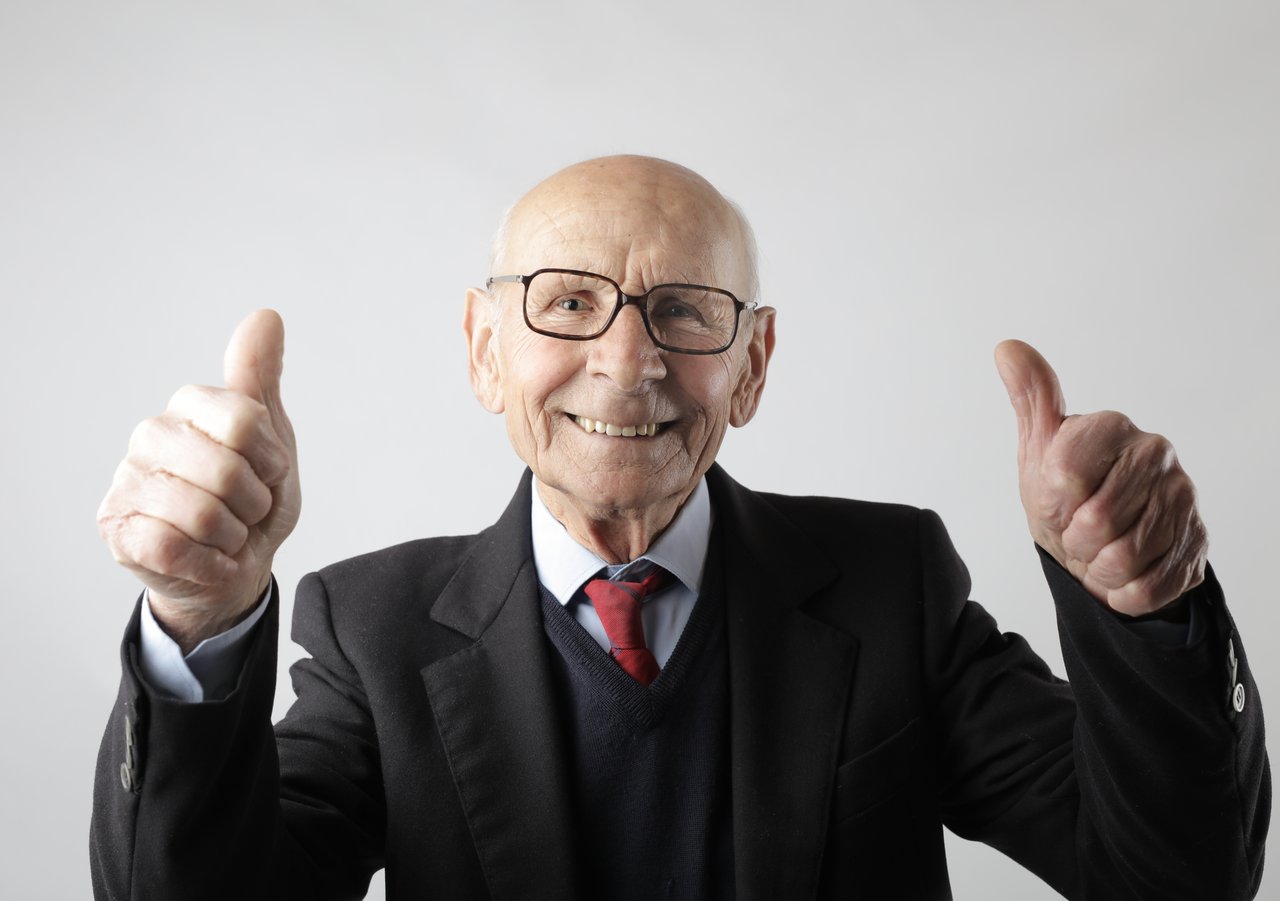 A cheerful bald man giving two thumbs up by Andrea Piacquadio